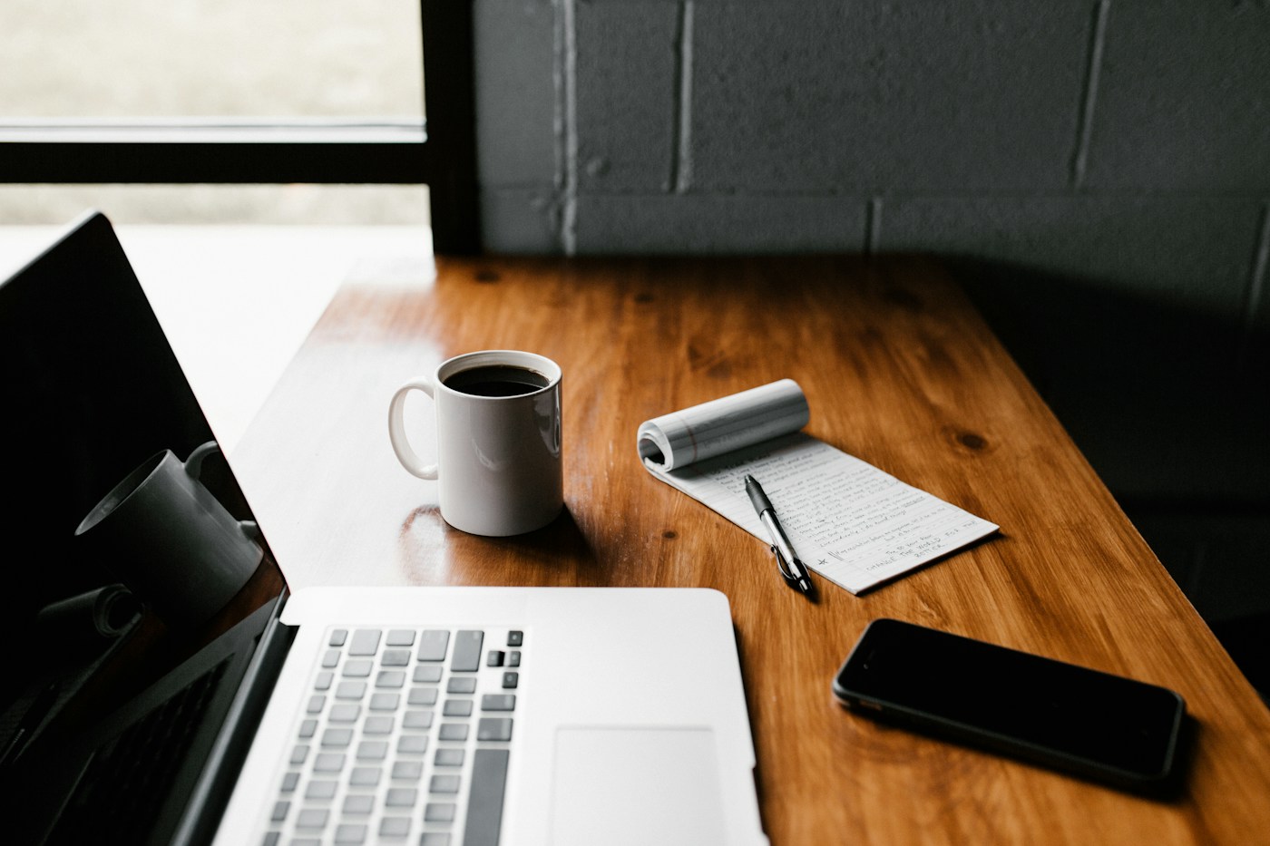 An open notebook and books on a writing desk